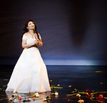 Retiree Bles Chavez-Bernstein singing on-stage.