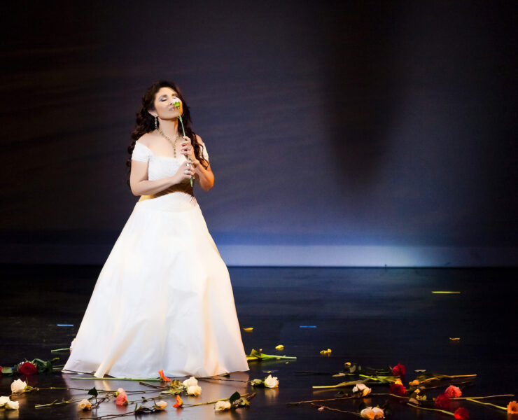 Retiree Bles Chavez-Bernstein singing on-stage.