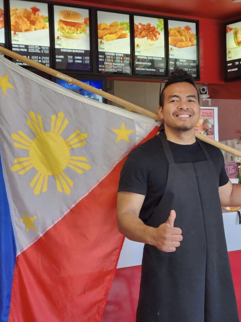 Filipino entrepreneur in Canada with Philippine flag.
